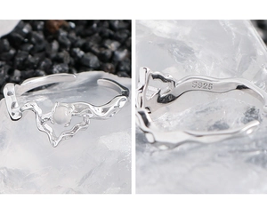 Macro shot of S925 sterling silver stamp and irregular wave ring with white bead detail