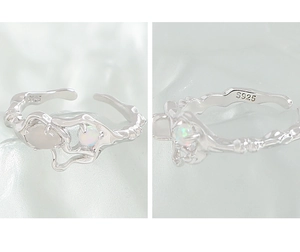 Macro detail of S925 sterling silver ring with liquid texture and iridescent opal stone
