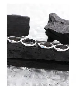 Close-up of S925 silver eye-shaped rings with colorful zircons on a textured black base