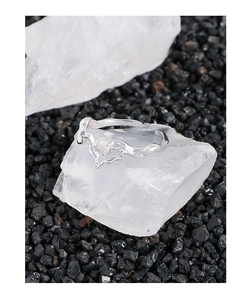 Macro shot of silver fluid lava ring with opal stone on a decorative white crystal