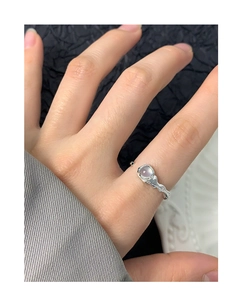 Detail of silver S925 ring with irregular texture and purple agate on a model's hand