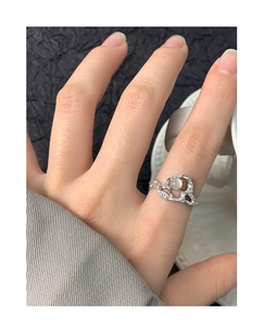 Irregular textured silver ring with round semi-transparent gemstone on finger