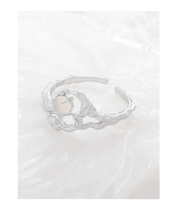 Macro detail of S925 sterling silver ring with irregular organic wave texture and opal bead