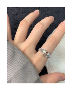 Detailed view of irregular fluid silver ring featuring opal stone on fingers