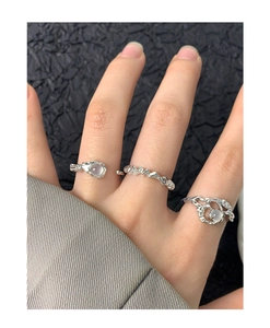 Detail of three S925 silver rings with round white stones and textured finish on hand