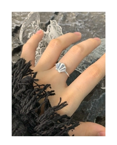 Close-up of S925 sterling silver shell ring worn on finger with elegant marble background