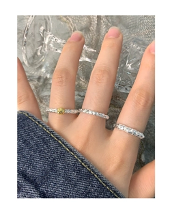 Makroaufnahme von Stapelringen aus Silber mit Hammerschlag-Textur und Goldperle