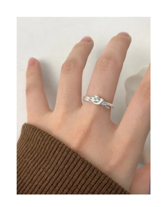 Detail of S925 sterling silver knot ring worn on finger with minimalist design