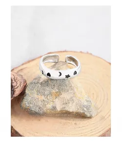Macro detail of S925 sterling silver ring with black star moon heart enamel patterns
