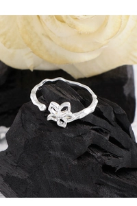 Detailed view of silver hollow flower ring with textured band and adjustable open design
