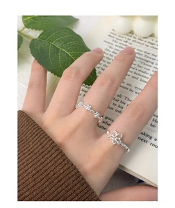 Detailed view of silver flower rings on finger with floral cutout and S925 style
