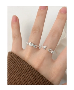 Detailed view of S925 sterling silver knotted ring set worn on a finger with knit sleeve