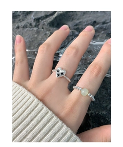 Détail de bagues en argent S925 avec motif étoile cœur et perle verte sur la main