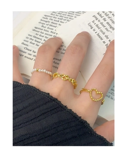 Detailed view of three-piece set with pearl ring and gold hollow heart-shaped designs