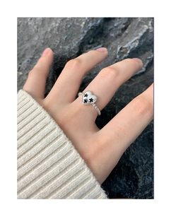 Détail d'une bague en argent S925 avec pendentif coeur et gravures d'étoiles noires