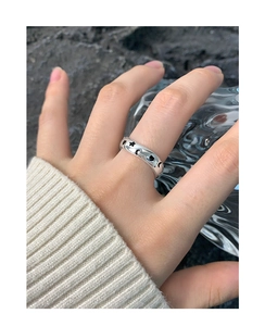 Macro detail of S925 silver ring featuring black star moon and heart graffiti patterns