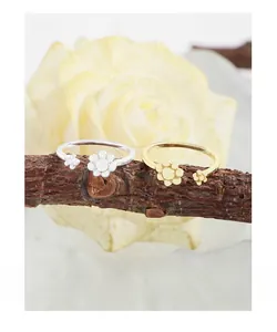 Macro shot of silver and gold S925 floral rings resting on natural wood branches