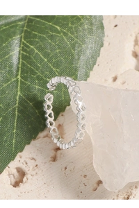 Vue détaillée d'une bague à motif de cœur évidé en argent sur fond de pierre naturelle