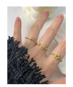 Three-piece set of gold floral and beaded S925 silver rings worn on female hand