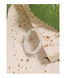 Détail macro de la bague en argent S925 avec cœurs évidés sur un fond en pierre naturelle