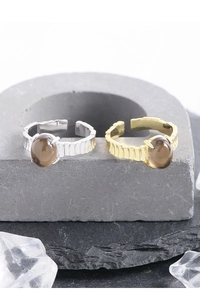 Vista macro de anillos ajustables de plata y oro con cuarzo ahumado y bandas texturizadas