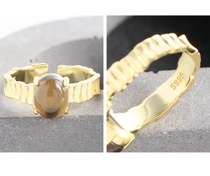 Detalle de la marca S925 y anillo dorado con piedra preciosa marrón ovalada