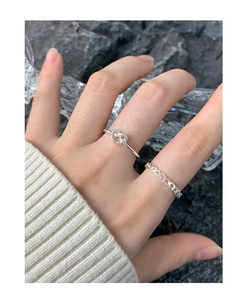 Bague noeud et coeur évidé en argent sur main avec fond pierre et cristal