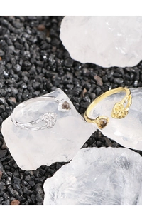 Detalle de anillos de corazón en oro y plata con cuarzo ahumado sobre cristal