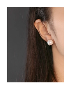 Detailansicht eines S925 Silberperlenohrrings mit rosa Zirkon-Akzenten am Ohr eines Models