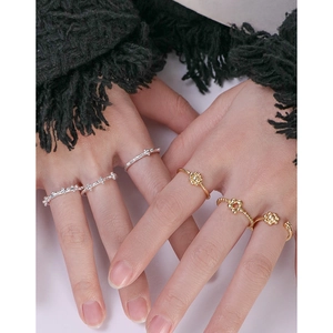 Set of minimalist S925 silver and gold floral rings worn for a stylish layered look