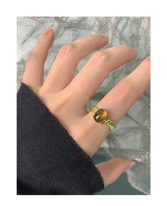 Detalle de anillo de plata S925 con cuarzo ahumado y banda dorada de textura estriada