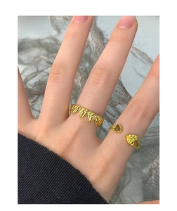 Detalle de anillos de plata S925 dorados con textura de corazón y piedra de cuarzo