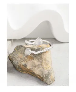 Macro shot of S925 silver ring with irregular twisted texture and dual white agate stones