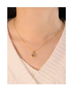 Primer plano de collar corazón con piedra lunar en modelo con jersey blanco
