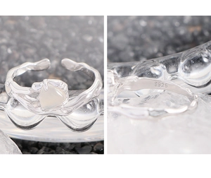 Macro detail of S925 sterling silver ring with liquid metal texture and heart stone