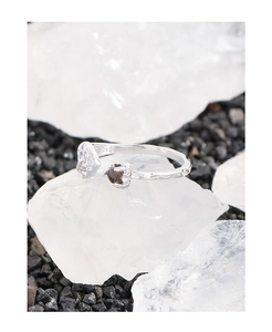Detalle del anillo de corazón de plata S925 con cristal marrón sobre piedra mineral blanca