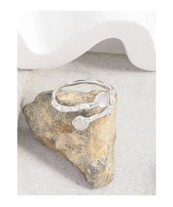 Detail of S925 silver irregular wave ring featuring dual white agate stones on natural rock