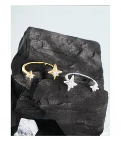Macro view of S925 sterling silver star rings with zircon inlay on a dark rock background
