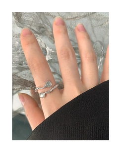 Detail of S925 sterling silver open ring with irregular twisted texture and green stones