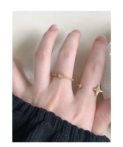 Close-up of S925 silver starburst zircon rings in gold finish worn on a hand
