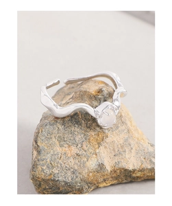Détail d'une bague vague en argent avec agate blanche sertie sur support minéral