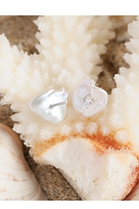 Macro detail of Baroque pearl earring with crystal inlay on a white coral branch