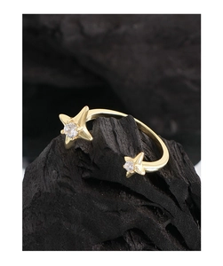 Close-up of golden S925 silver star ring with zircon stones on charcoal display