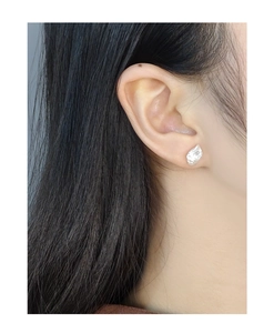 Close-up of S925 silver baroque irregular pearl earring worn on model's ear