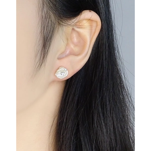 Baroque pearl stud earring with zircon inlay worn by model in a natural setting