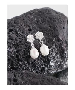 Détail de boucles d'oreilles fleur en argent avec perles d'eau douce blanches suspendues