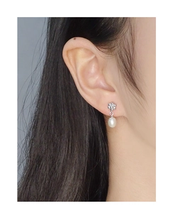 Gros plan sur boucle d'oreille fleur en argent S925 avec strass et perle d'eau douce