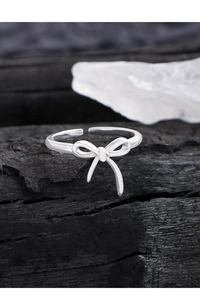 Macro de la bague nœud papillon en argent massif S925 sur fond de charbon de bois noir