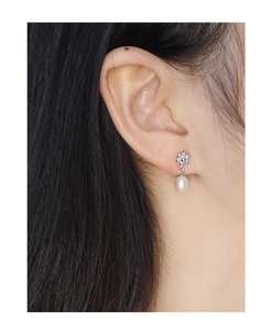 Boucle d'oreille fleur en argent S925 avec perle d'eau douce blanche sur l'oreille