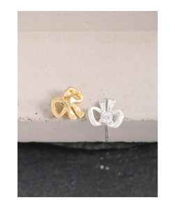 Macro detail of S925 sterling silver bow earrings with zircon stones in gold and silver